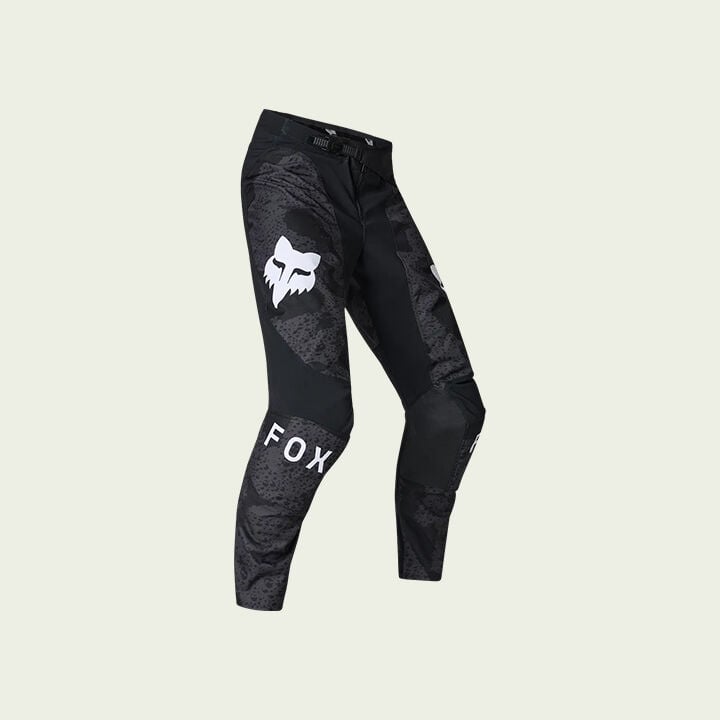 black moto pants on green background